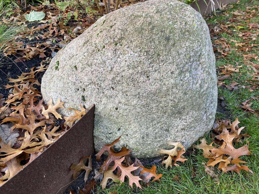   Die Stahlkanten um die Hochbeete sind in die Findlinge eingeschnitten.