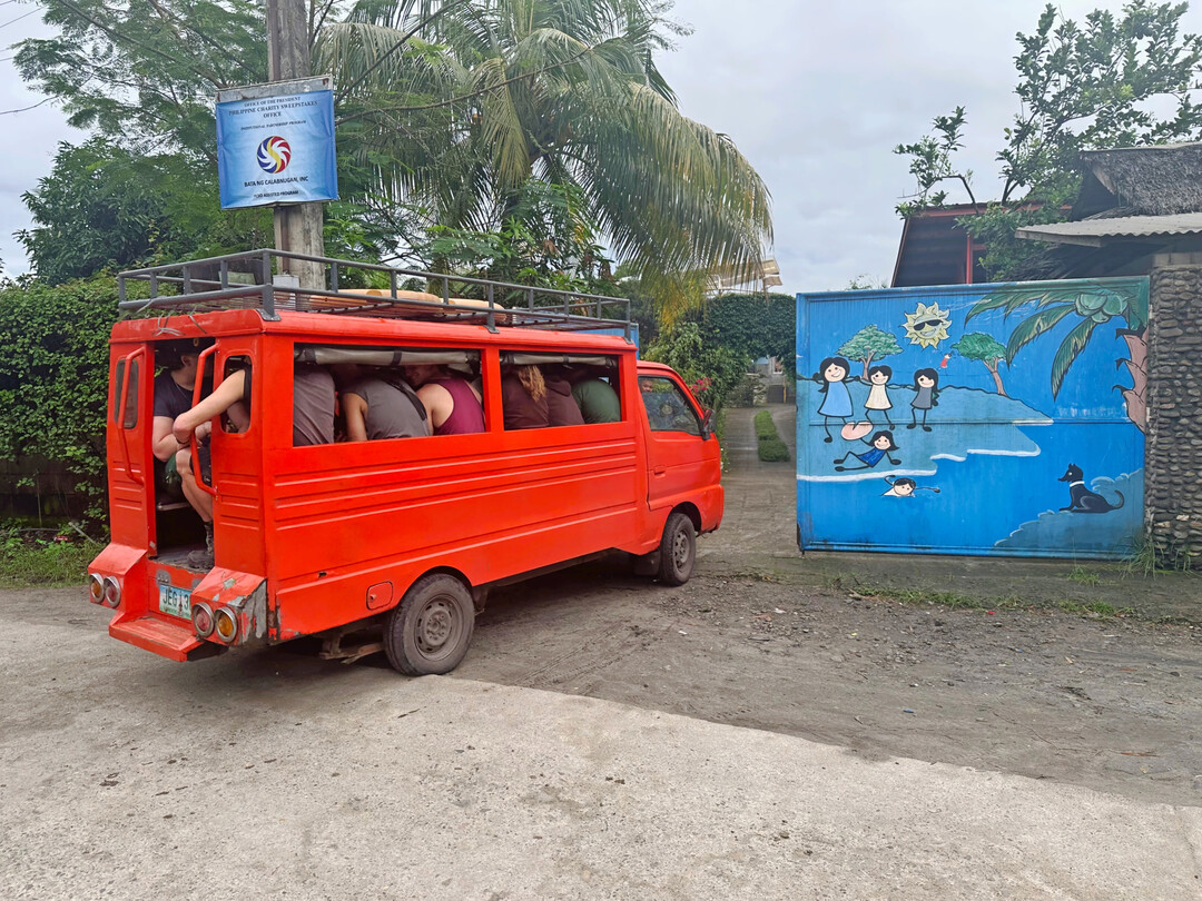 Das Tor zum Waisenhaus in Calabnugan bei Dumaguete geht auf. Nicht zu glauben: 14 Leute lassen sich mit diesem 600-ccm-Fahrzeug zur Baustelle befrdern.
