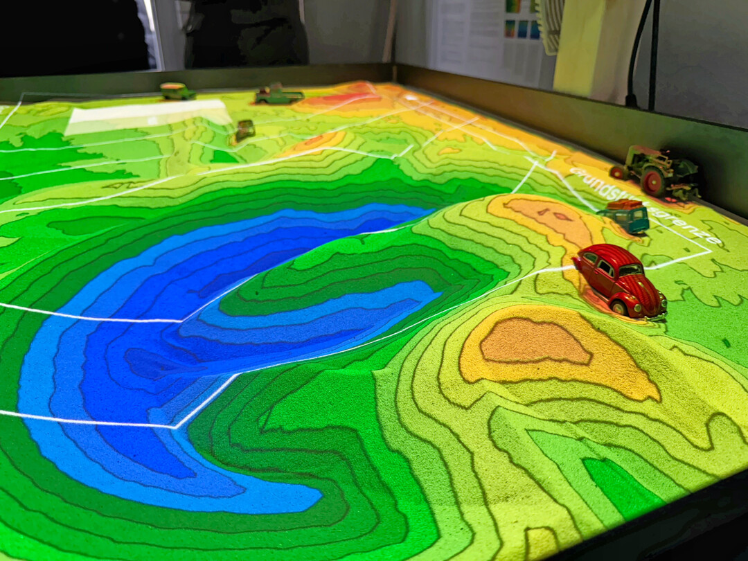 Mit der AR-Sandbox knnen 2D Plne in 3D dargestellt werden und mittels Starkregensimulation auf berflutungsgefahren hin berprft werden.