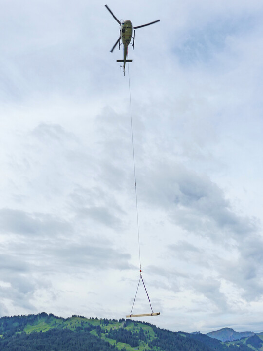 Für den Lawinenverbau werden die Materialien mit dem Hubschrauber auf den Berg gebracht.