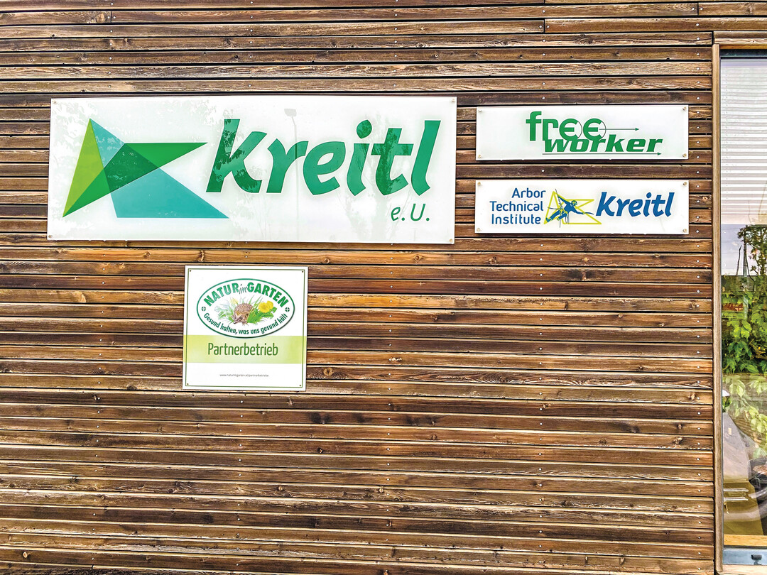 Neben dem Logo hngen an der Fassade in Raasdorf die Schilder des Shops, des Instituts und der Initiative Natur im Garten.