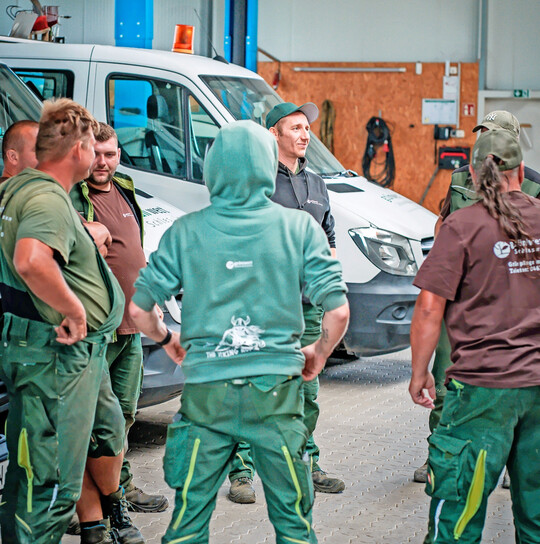 Mitarbeiter in der Pflege tragen das GrünWert-Logo – angepasst an den jeweiligen Betrieb – auf ihrer Arbeitskleidung.