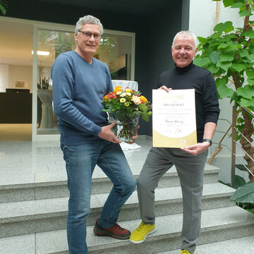 Andreas Baranski (links) bergab Reiner Bierig (rechts) die Urkunde und einen Blumengru im Namen aller Kollegen des Verbands.