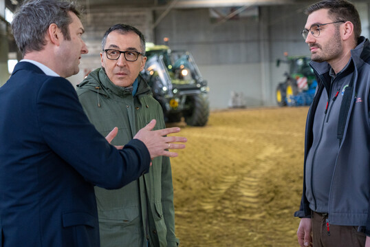 Bundeslandwirtschaftsminister Özdemir ließ sich jede Station auf dem DEULA-Rundgang genau erklären. (Im Bild Marco Riley zusammen mit einem Ausbilder sowie Cem Özdemir.)