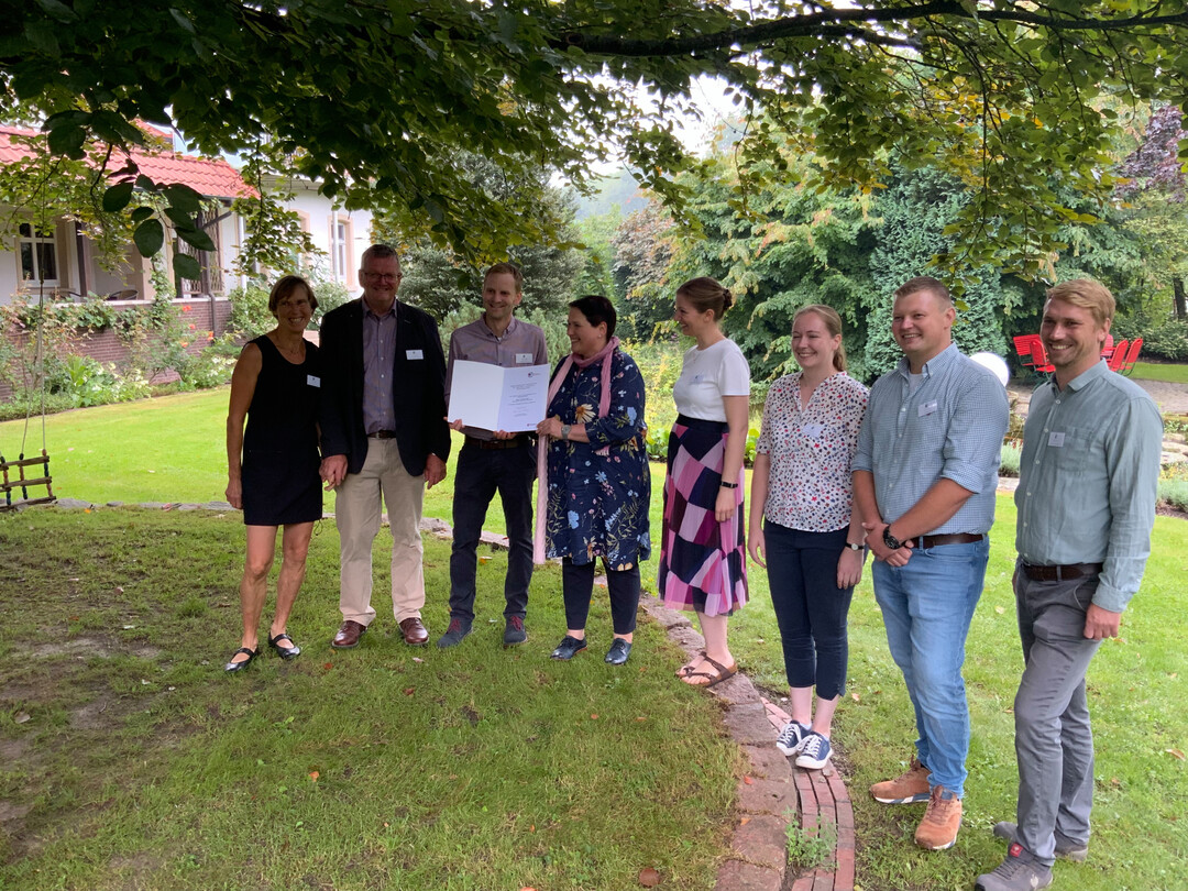 Melanie Walter (3.v.l.) berreicht die Auszeichnung fr besonders verlssliche Ausbildung an Marianne, Rolf, Lars und Verena Meyer zu Hrste sowie das AusbilderInnen-Team Roswitha Somberg, Tim Bentrup und Philipp Heggemann (v.l.n.r)