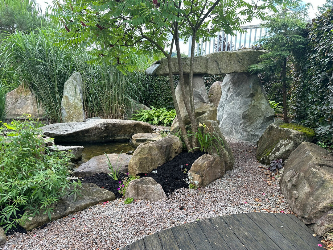 Dort zeigt die Firma Gartenkunst mit Pflanzen und Naturstein.