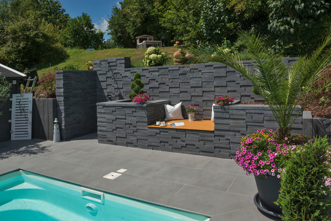 Mit der Basalo-Mauer von KANN lassen sich abwechslungs-reiche Gestaltungen im Garten und an der Terrasse umset-zen. Unterschiedliche Höhen und ein integrierter Sitzplatz schaffen eine individuelle Atmosphäre.