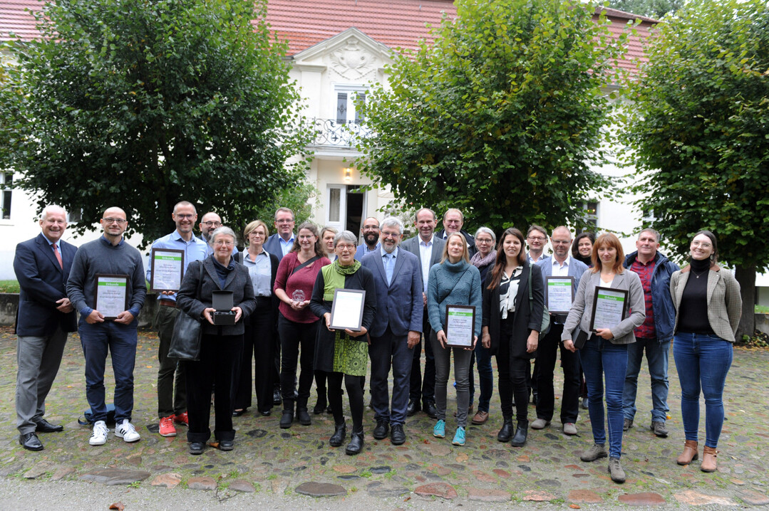 Gruppenfoto der Sieger des Wettbewerbs mit dem brandenburgischen Umweltminister Axel Vogel im Vordergrund vor dem Schloss Blankensee