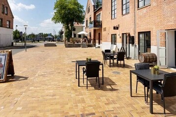 In der dnischen Eisenbahnstadt Brdstrup wurde der zentrale Bahnhofsplatz Banetorv in einer aufwendigen Sanierung aufgewertet. Optisch verbunden mit der Umgebung wird der Ort durch eine einheitliche Gestaltung des Bodenbelags mit Pflasterklinker. 