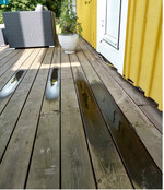 Terrassendeck aus schutzmittelbehandelter Kiefer. Konstruktiv bedingt wird Regenwasser nicht vollständig von der Holzoberfläche abgeführt.