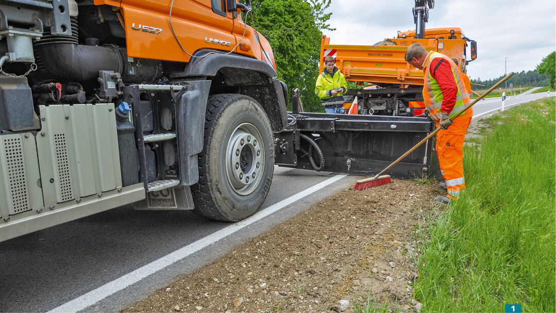 Gehwege, Seitenstreifen und Bankette formt der Seitenverteiler von amtec abt. Er kann an Radlader und Kommunalfahrzeuge angebaut werden.