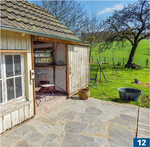 Hühnerhäuschen aus den 1960er-Jahren, restauriert mit vorhandenem Holz aus der Fassade mit Schiebetor. Davor Polygonalplatten aus Sandsteinquarzit