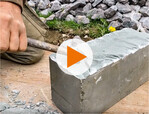 Frank Schroeder bossiert einen geschnittenen Grauwacke-Block mit 2-kg-Hammer und Eisen.
