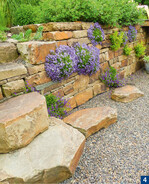 Die typischen braunen Krusten der Bergischen Grauwacke und die integrierten Pflanzen – auch typische Gestaltungsmerkmale der Gartenmanufaktur