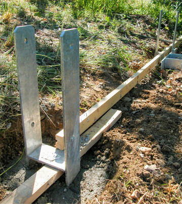 H-Anker oder Pfostenschuhe verhindern den Kontakt des Holzpfostens mit dem Boden.
