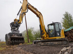 Maximale Flexibilität eingebaut: Ein Caterpillar-Kompaktbagger mit Forstmulcher und einem Oilquick-Tiltrotator für schnelle Werkzeugwechsel.