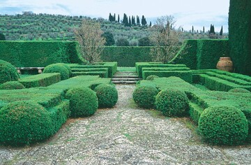 Der Garten der Villa Gamberaia, im Hintergrund die toskanische Landschaft  angeregt durch einen Mittelmeerurlaub wollen viele mediterranes Flair auch im heimischen Garten