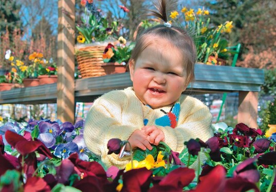 Besucherin Hanna, zehn Monate alt, geniet Blumen und Sonnenschein