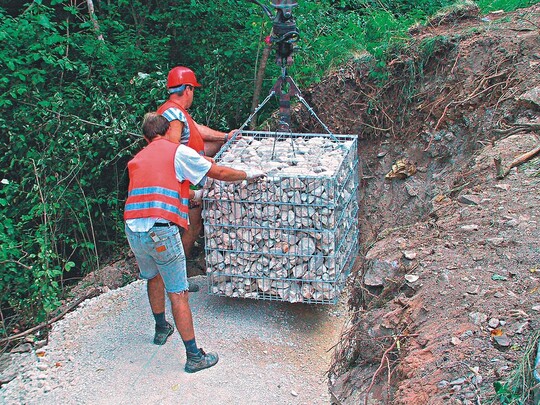 Kommt fertig auf die Baustelle: rawe-Steinkorb mit Kalksteinfllung beim Versetzen auf Schotterfundament