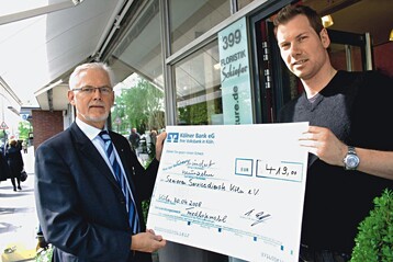 Josef Terfrchte, Geschftsfhrer des Fachverbands Klner Friedhofsgrtner (li.), nimmt den Scheck fr das neue Friedhofsmobil von Torsten Schiefer entgegen