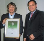 Arnold Wiegmann (links), Geschäftsführer der Firma Grewe, erhielt aus den Händen von Thomas Wirz, Geschäftsführer der Sozialversicherungsträger für den Gartenbau, die AMSBescheinigung