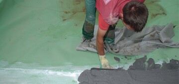 Eine Schicht aus Estrich, Mrtel oder Beton soll die Dichtungsbahn vor Schden durch statische Aufbauten oder regelmige Pflegemanahmen schtzen.