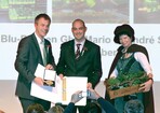 NRW-Umweltminister Johannes Remmel (l.) übergibt Firmeninhaber Mario Segler (Mitte) den Gartenbaupreis 2012