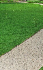 1 Splittbelag mit Unterbau aus 10 cm Frostschutzschicht und 10 cm Einkornbeton. Seitliche Begrenzung mit Stahlkante. Deckschicht aus Kalksteinsplitt, Körnung 5-8 mm, von Franken-Schotter in Petersbuch.