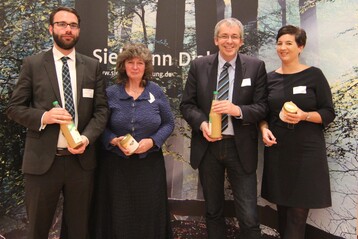 Die Diskutanten des Sielmann-Dialogs freuen sich ber ein Dankeschn der Heinz Sielmann Stiftung - Apfelsaft und Honig vom Gut Herbigshagen. Abgebildet sind von links nach rechts: Tobias Hartmann, KPMG AG Wirtschaftsprfungsgesellschaft Marion Hammerl, Global Nature Fund Prof. Dr. Bernd Hansjrgens, Helmholtz-Zentrum fr Umweltforschung GmbH Carolin Bomeyer, Biodiversity in Good Company Initiative e.V. Weiterer Podiumsteilnehmer: Dr. Kilian Delbrck, Bundesministerium fr Umwelt, Naturschutz, Bau und Reaktorsicherheit