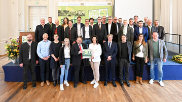 Michaela Kaniber (Mitte), Bayerische Staatsministerin fr Ernhrung, Landwirtschaft und Forsten, und Gerhard Zh (links dabenen), Prsident des Verbandes Garten-, Landschafts- und Sportplatzbau Bayern, zusammen mit den Preistrgerinnen und Preistrgern der Staatsehrenpreise fr vorbildliche Ausbildung im Garten- und Landschaftsbau 2023.