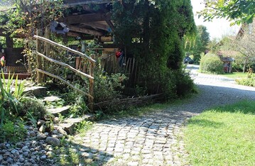 Beispiel einer naturnah orientierten Gartengestaltung ist der Zugang 
zum Gemeinschaftsplatz der kosiedlung in Aach, ein Ortsteil des Marktes Oberstaufen 
im Landkreis Oberallgu. 