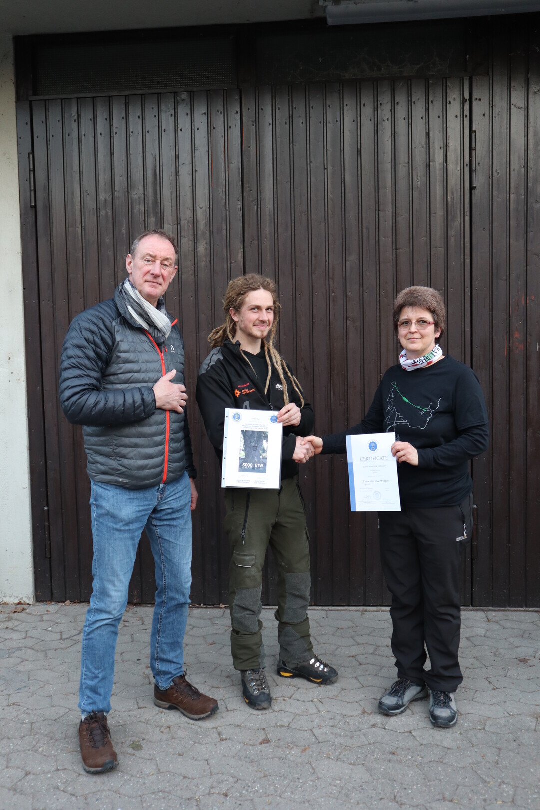 Quirin Irmscher (Mitte) ist der 5.000 zertifizierte European Tree Worker. Petra Werner (rechts), Leiterin des Sachgebiets Baumpflege an der LVG Heidelberg, berreichte ihm das Zertifikat in Gegenwart von EAC-Supervisor Henk van Scherpenzeel, NL.