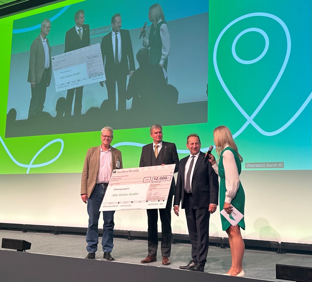 V. l. Philipp Sattler, Vorsitzender Stiftung Die Grne Stadt nimmt einen Spendenscheck der NrnbergMesse von deren CEO Peter Ottmann entgegen. Dabei auch BGL-Prsident Thomas Banzhaf, und Moderatorin Tanja Neumann.<br>
