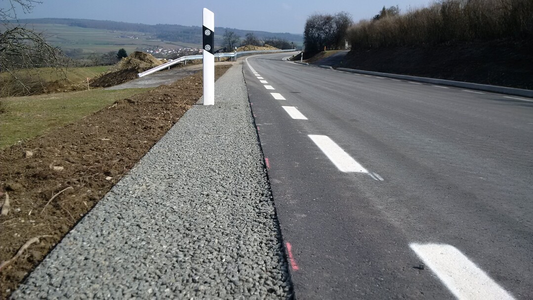 Von Wallstop mit einem Gleitschalungsfertiger hergestelltes power-Bankett entlang einer Kreisstraße (50 cm breit, 23 cm hoch).